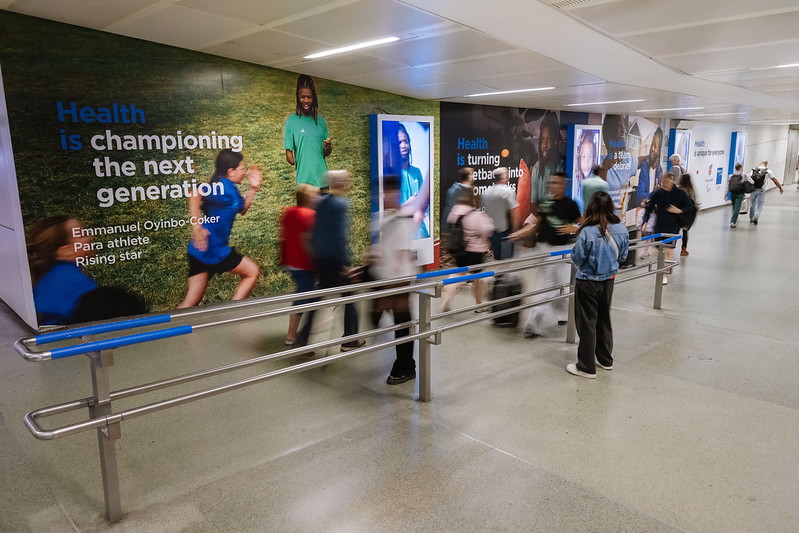 Sation advertising with mixture of large scale print posters and digital screens